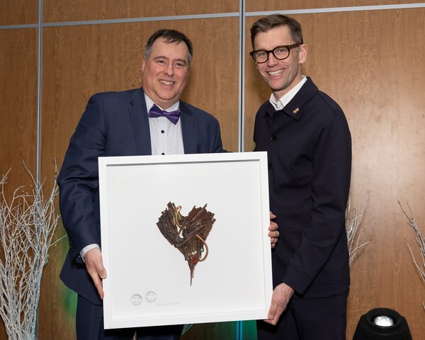 Luc Beaulieu, ambassadeur de l'année 2024, tenant un cadre honorifique en compagnie du maire de la ville de Québec, Bruno Marchand.